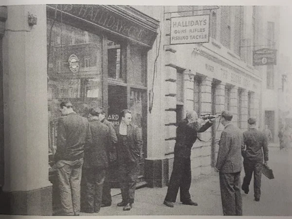 Vintage black and white still of shop owner